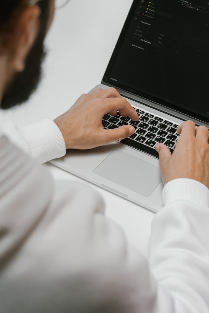 about-02 A male programmer intensely typing code on a laptop, showcasing modern technology and software development.